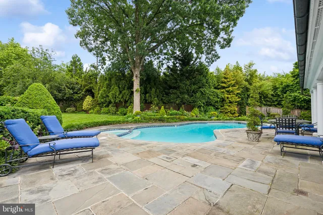 a view of a house with swimming pool and sitting area