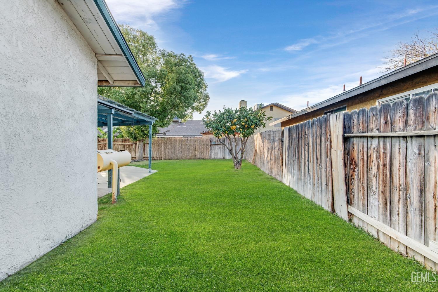 Undisclosed Address Bakersfield, CA 93313 - Photo 27 of 33 a view of backyard with green space and wooden fence