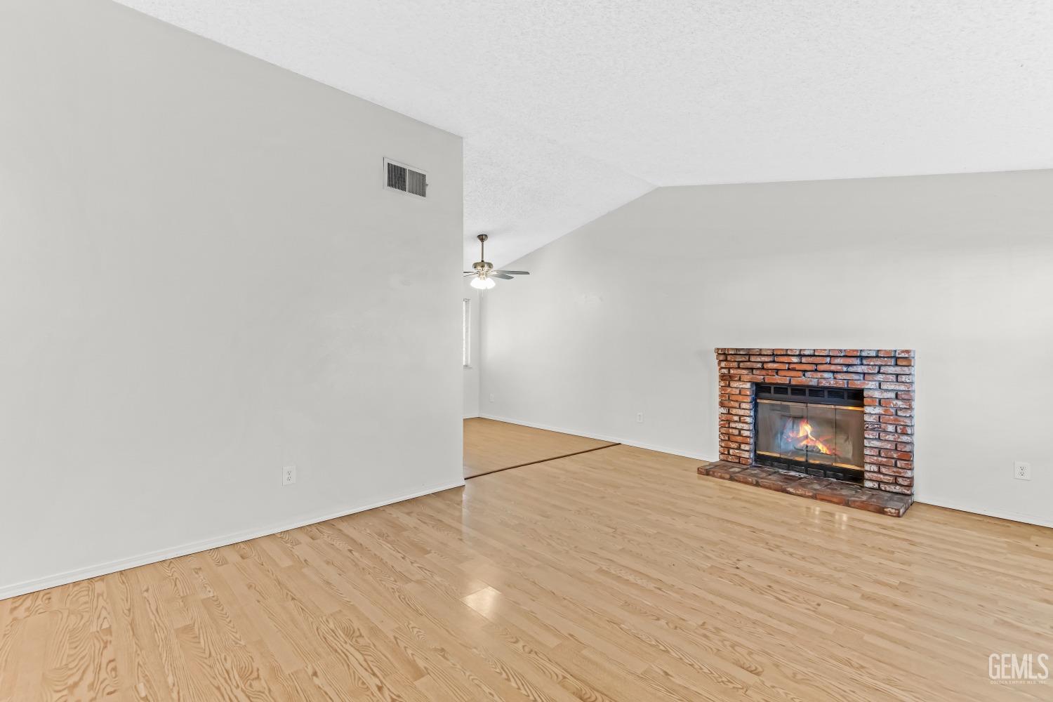 Undisclosed Address Bakersfield, CA 93313 - Photo 7 of 33 a view of empty room with wooden floor and fireplace