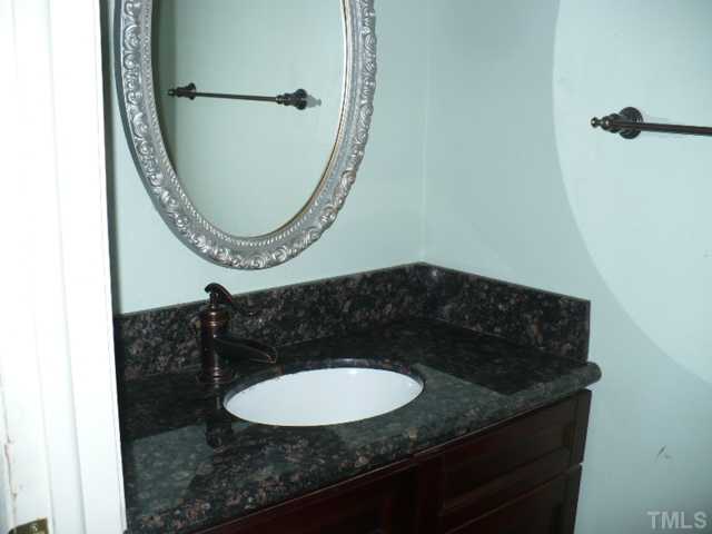 7723 Ohmann Court Raleigh, NC 27615 - Photo 8 of 16 a bathroom with a granite countertop sink and mirror
