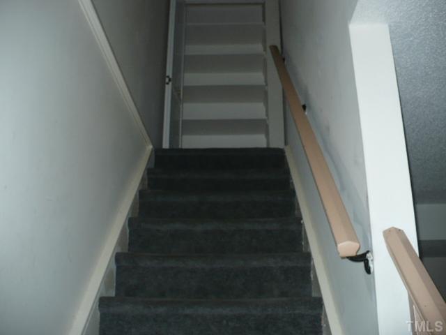 7723 Ohmann Court Raleigh, NC 27615 - Photo 10 of 16 a view of staircase with white walls
