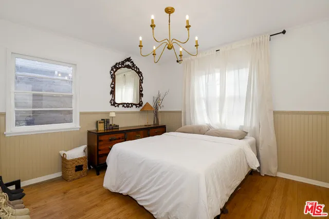 a bedroom with a bed and a chandelier
