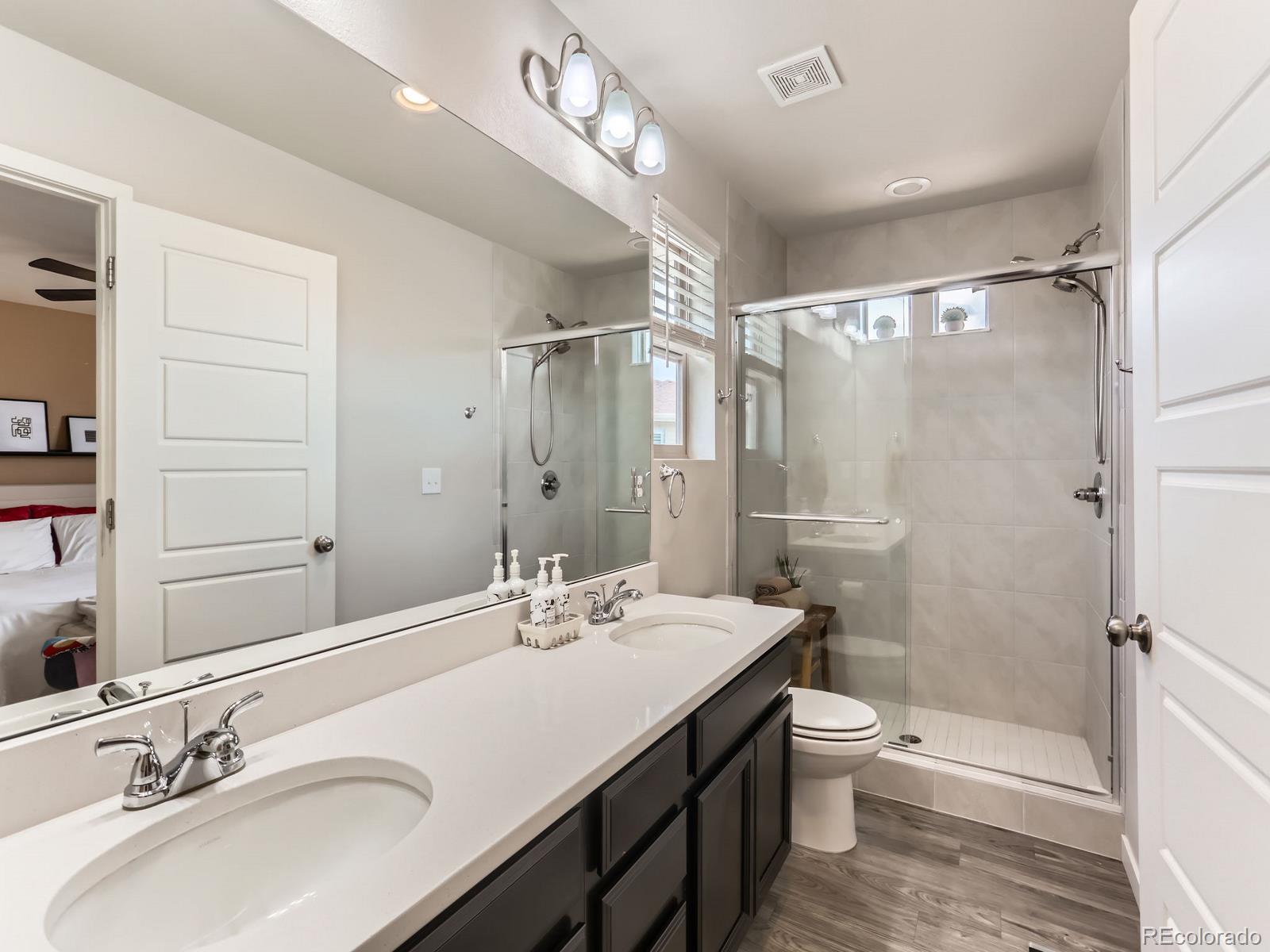 2899 Merry Rest Way Castle Rock, CO 80109 - Photo 17 of 39 a bathroom with a double vanity sink toilet mirror and shower