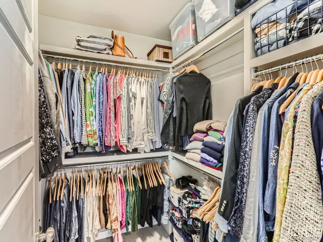 a view of walk in closet with clothes and shoes