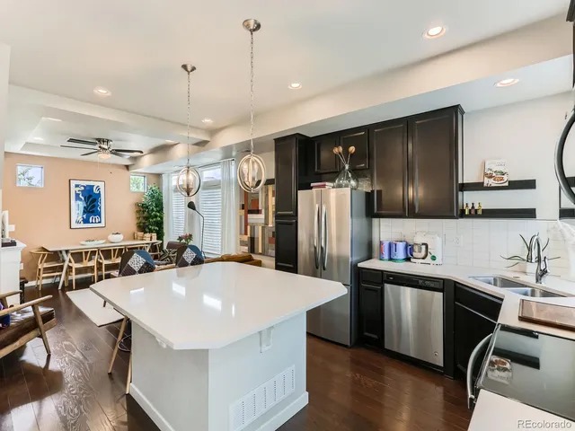 a kitchen with stainless steel appliances a sink a counter top space cabinets and wooden floor