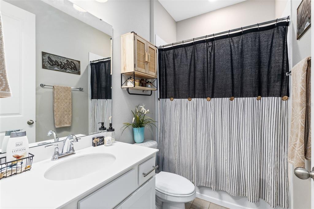 4160 Southern Vista Loop St. Cloud, FL 34772 - Photo 11 of 36 a bathroom with a sink a toilet and shower curtain