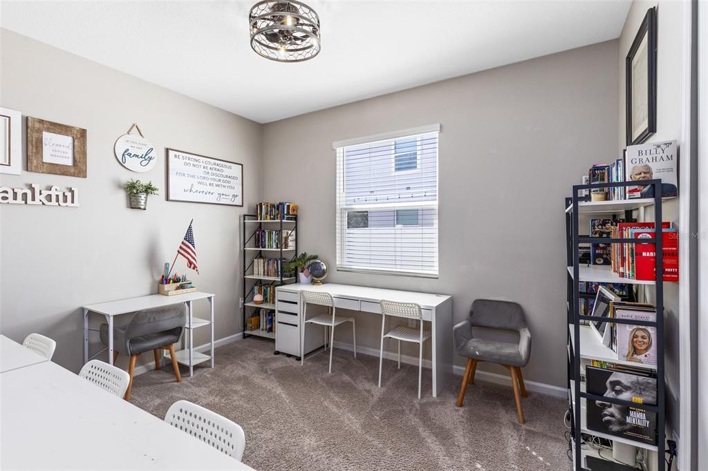 4160 Southern Vista Loop St. Cloud, FL 34772 - Photo 12 of 36 a room with furniture a desk and a book shelf