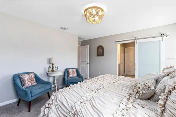 a bedroom with a bed and a chair