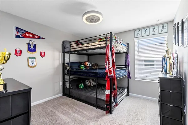 a bedroom with a bed and a refrigerator
