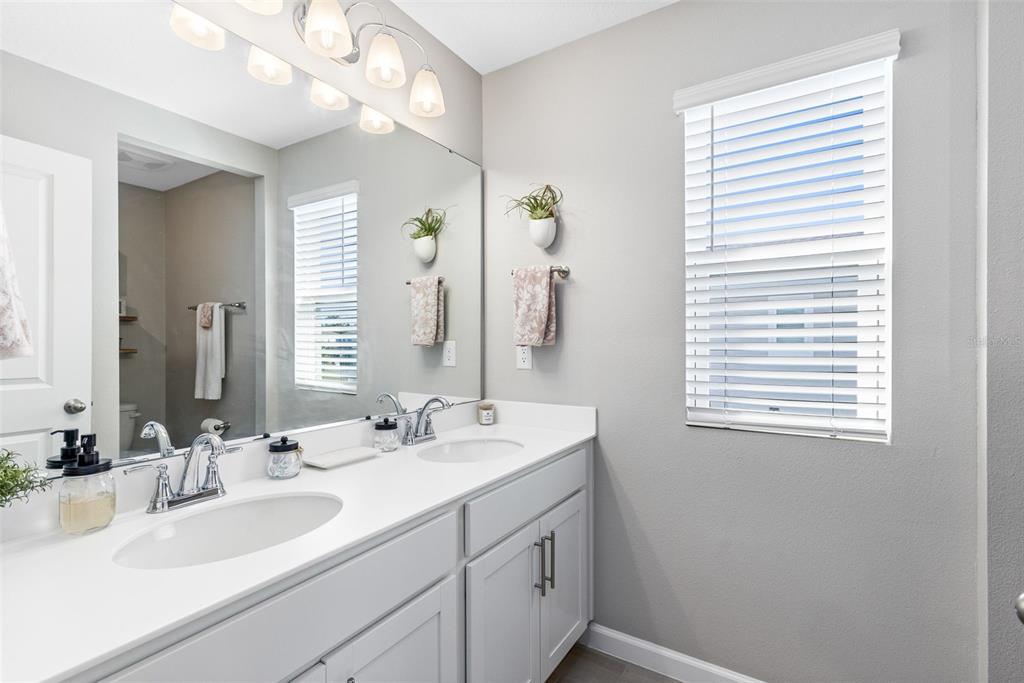 4160 Southern Vista Loop St. Cloud, FL 34772 - Photo 22 of 36 a bathroom with a sink a vanity and a mirror