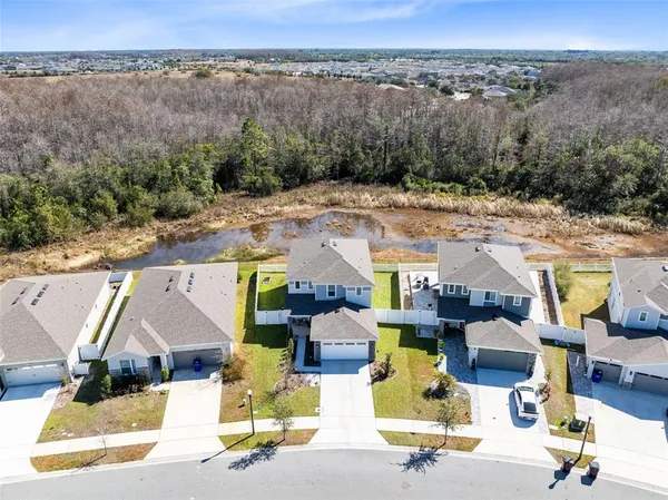 an aerial view of residential houses with outdoor space and parking