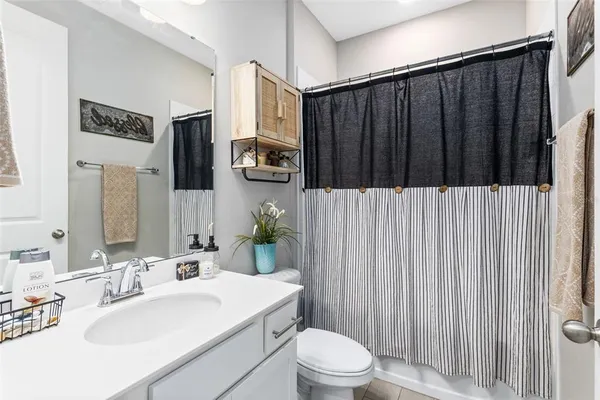 a bathroom with a sink a toilet and shower curtain