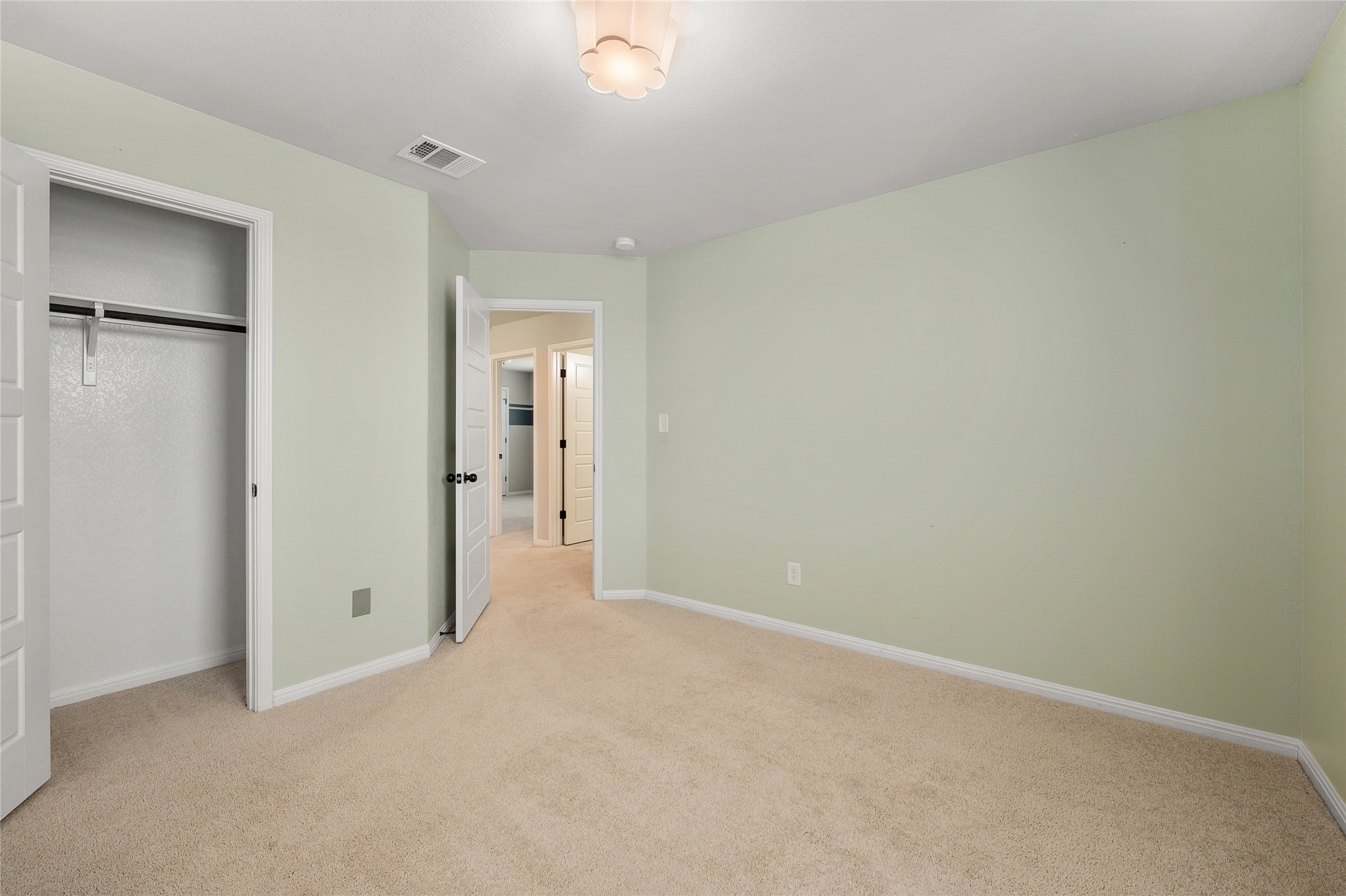 101 Lambert Street Leander, TX 78641 - Photo 25 of 33 A well-lit bedroom features plush carpeting and convenient closet space, leading to an adjoining hallway.