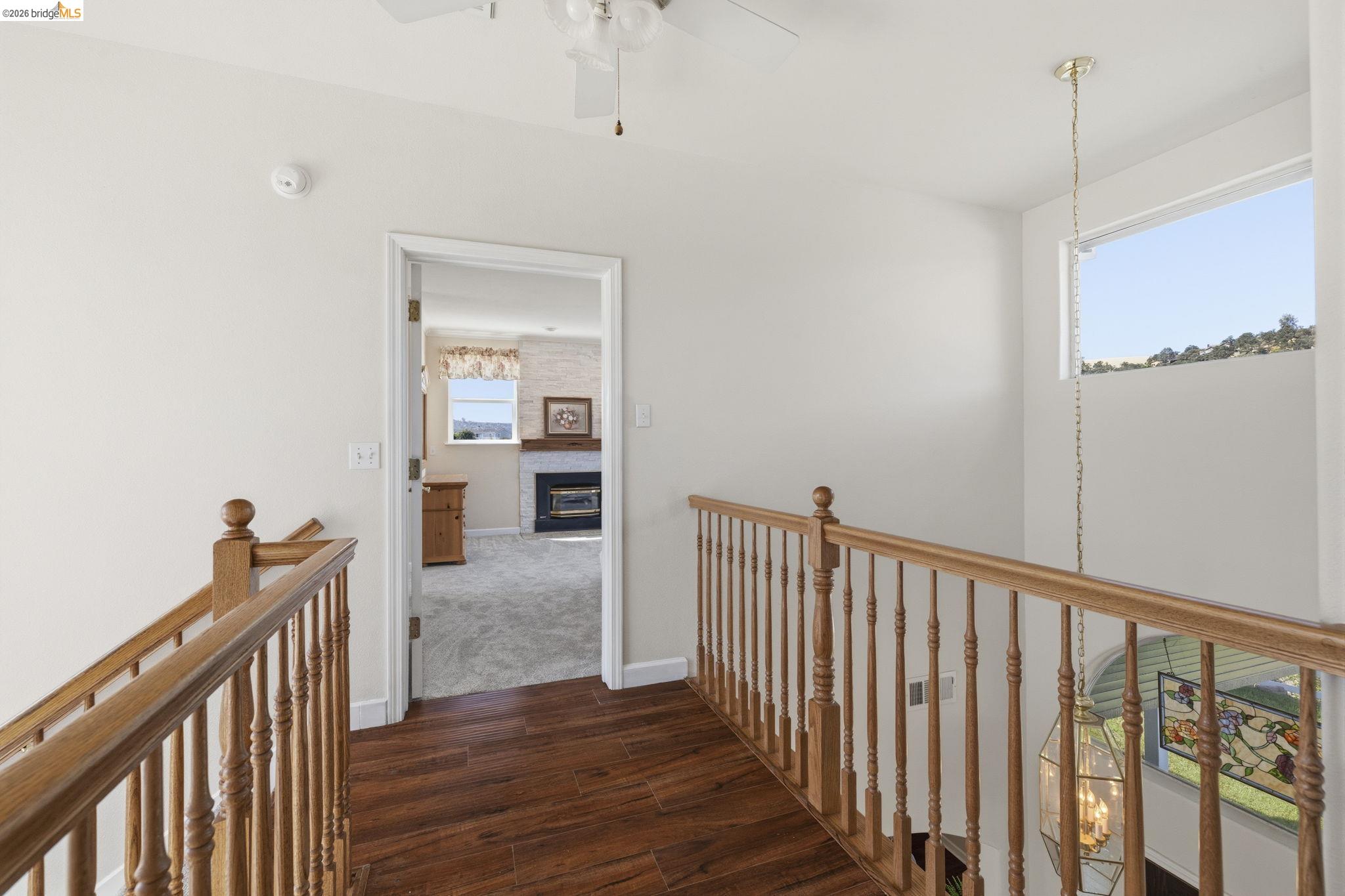 6242 Bluff View Road Copperopolis, CA 95228 - Photo 28 of 59 Upper-level hallway featuring wood-finish flooring, natural wood railings, and a decorative pendant light fixture