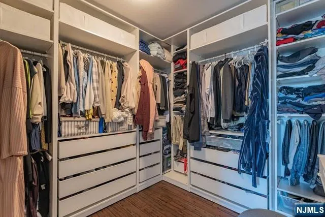 a view of walk in closet with clothes and shoes
