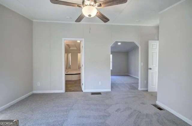 an empty room with closet and a chandelier fan