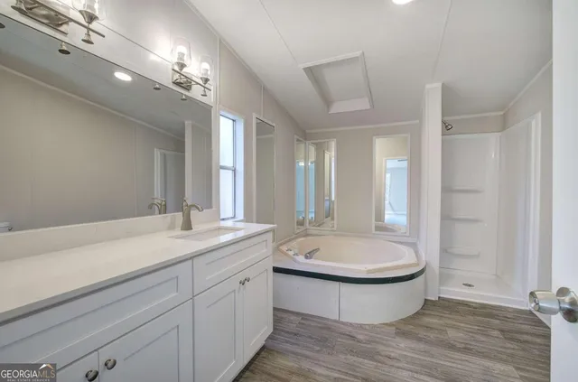 a bathroom with a double vanity sink a mirror and a bathtub