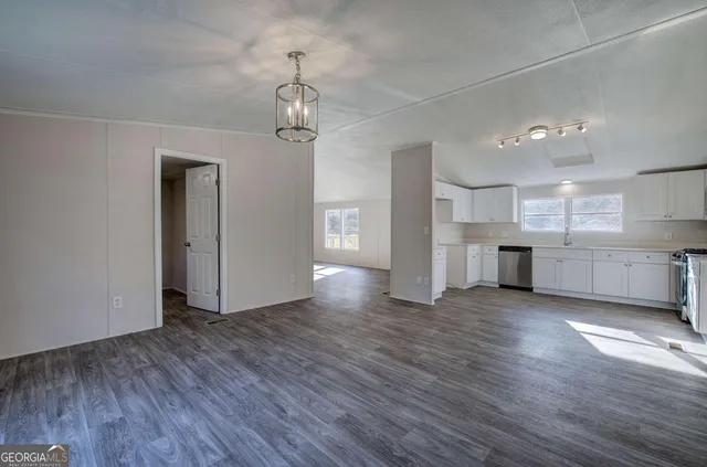 a view of a kitchen with a fridge wooden floor and a window