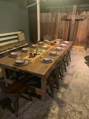 a dining table with chairs and white cabinets