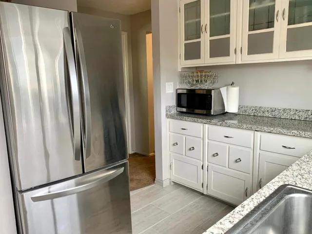 a kitchen with stainless steel appliances granite countertop a refrigerator and a sink