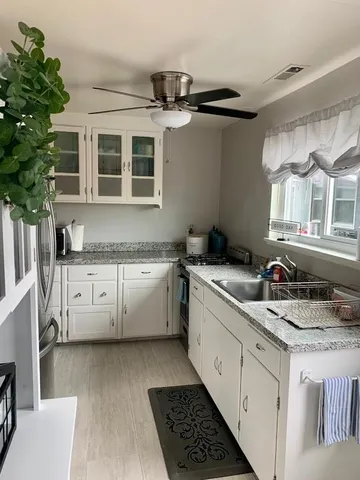a white kitchen with a sink and cabinets
