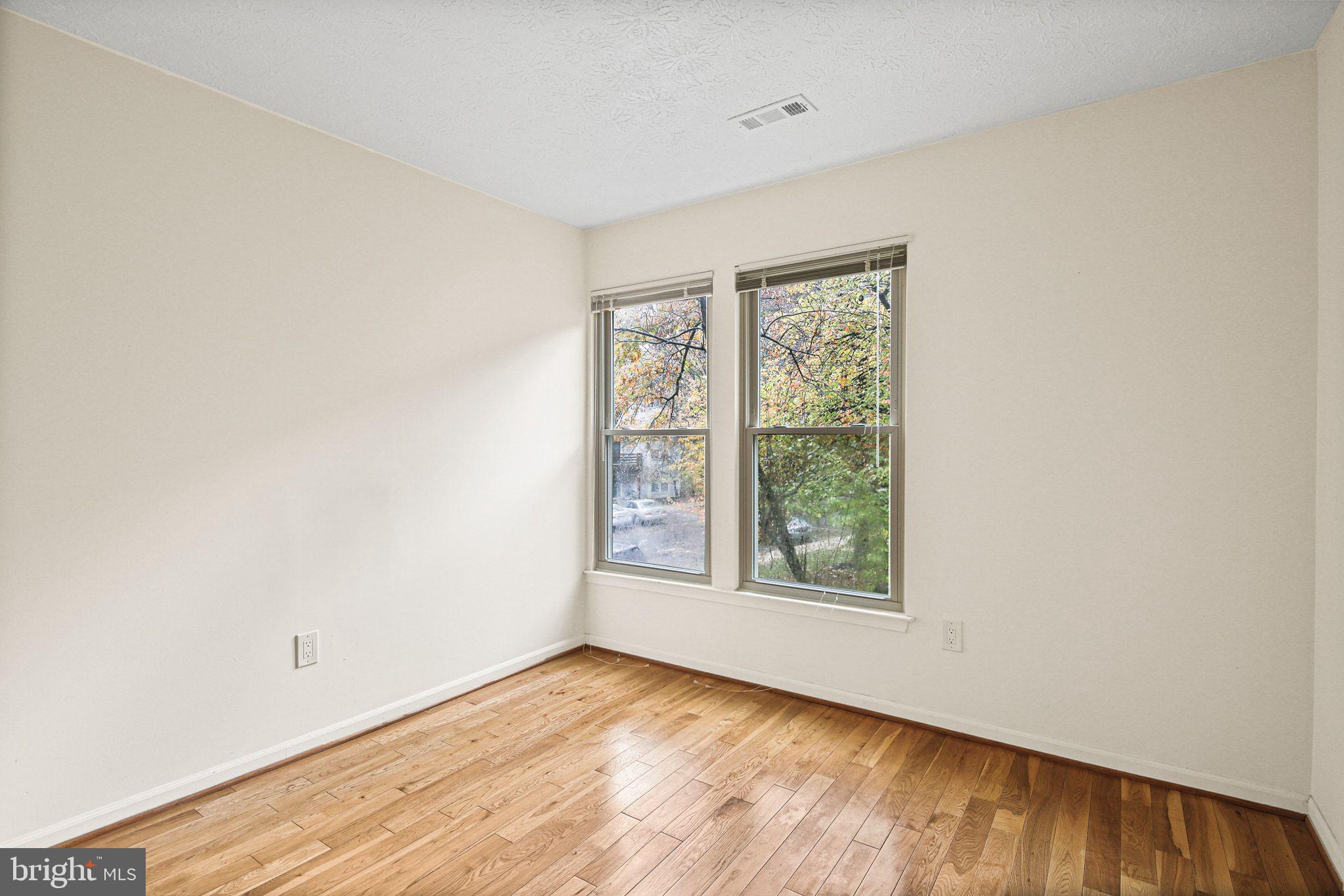 11450 Little Patuxent Parkway, Unit 605 Columbia, MD 21044 - Photo 20 of 33 an empty room with wooden floor and windows
