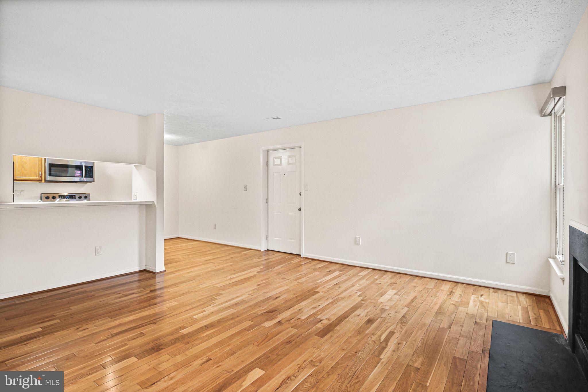 11450 Little Patuxent Parkway, Unit 605 Columbia, MD 21044 - Photo 5 of 33 a view of an empty room with wooden floor and a window