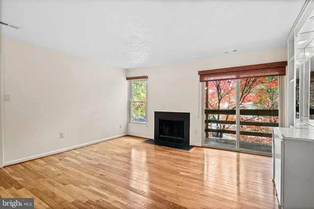 a view of empty room with wooden floor and fireplace