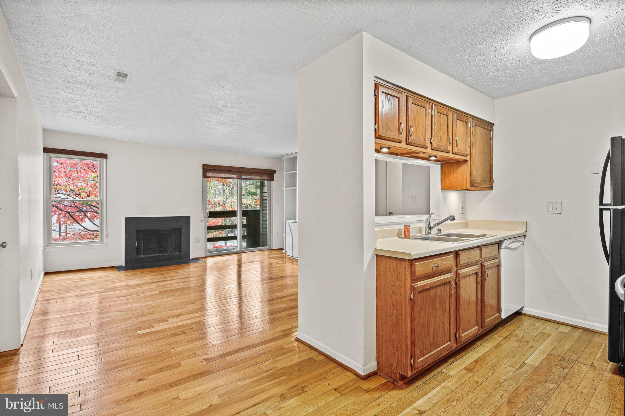 11450 Little Patuxent Parkway, Unit 605 Columbia, MD 21044 - Photo 10 of 33 a view of kitchen with granite countertop cabinets and wooden floor