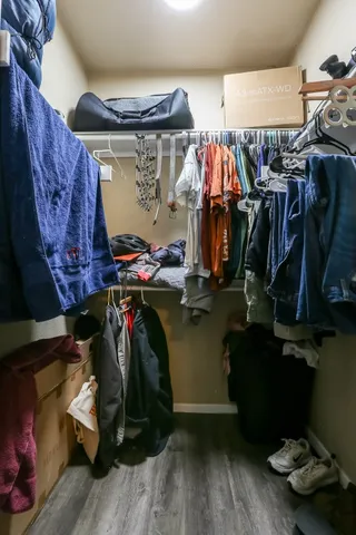 a view of walk in closet with clothes and shoes