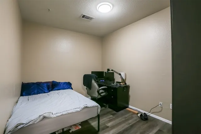 a bedroom with a bed and wooden floor