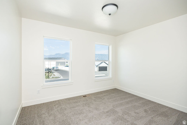 3308 South 1000 West Logan, UT 84321 - Photo 20 of 30 Neutral painted walls, two windows, grey carpet flooring, and a ceiling-mounted light fixture