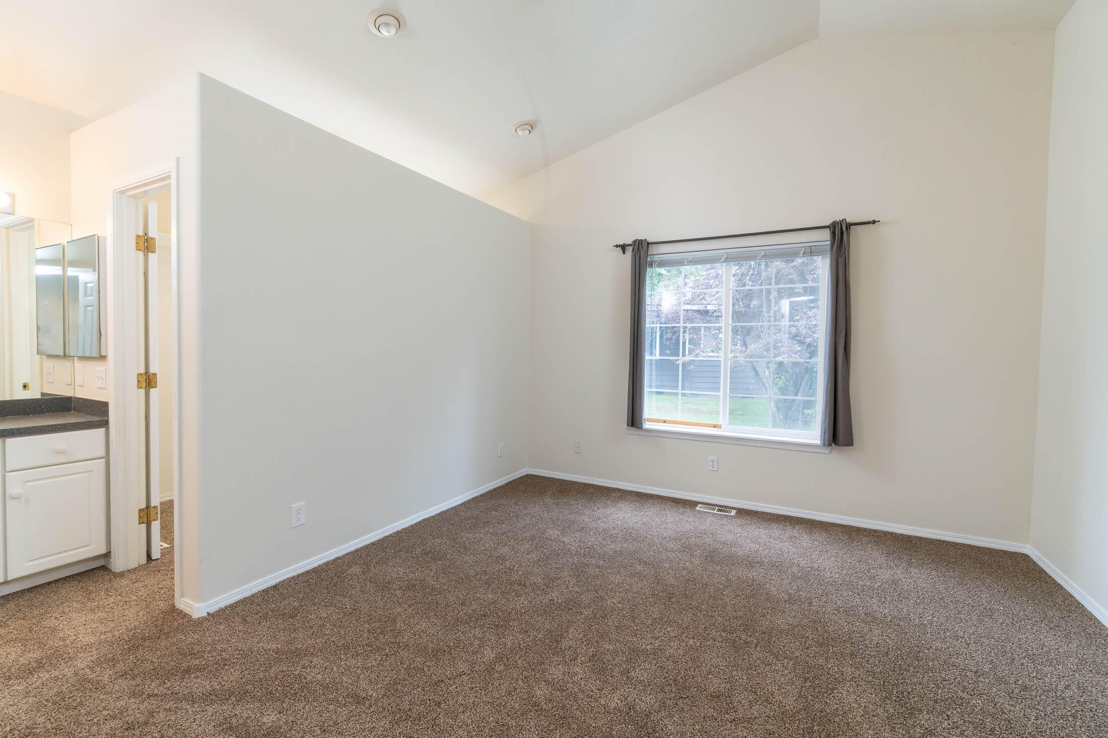 3389 Northeast Stonebrook Loop Bend, OR 97701 - Photo 14 of 27 Larger primary bedroom-bath and vaulted ceiling with a ceiling fan.