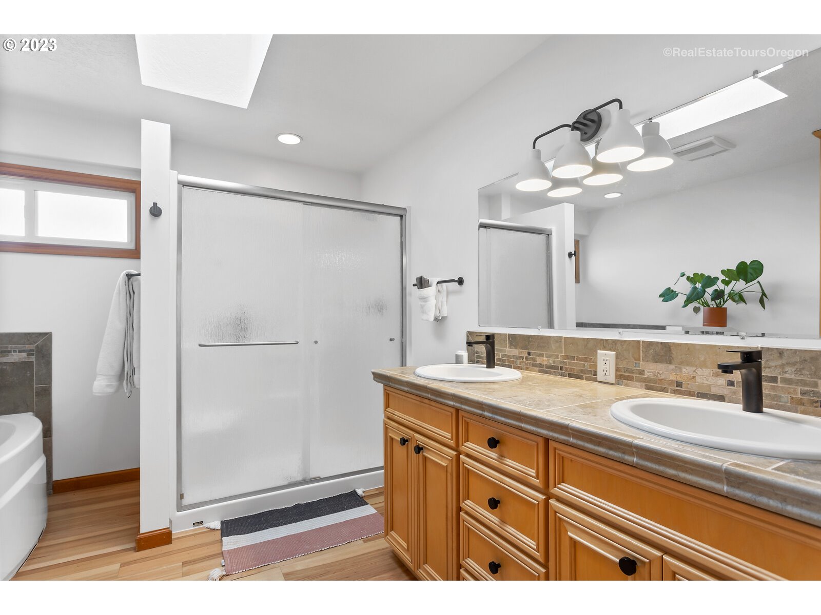 17224 Northwest Lucy Reeder Road Portland, OR 97231 - Photo 13 of 27 a bathroom with a granite countertop sink a mirror and a shower