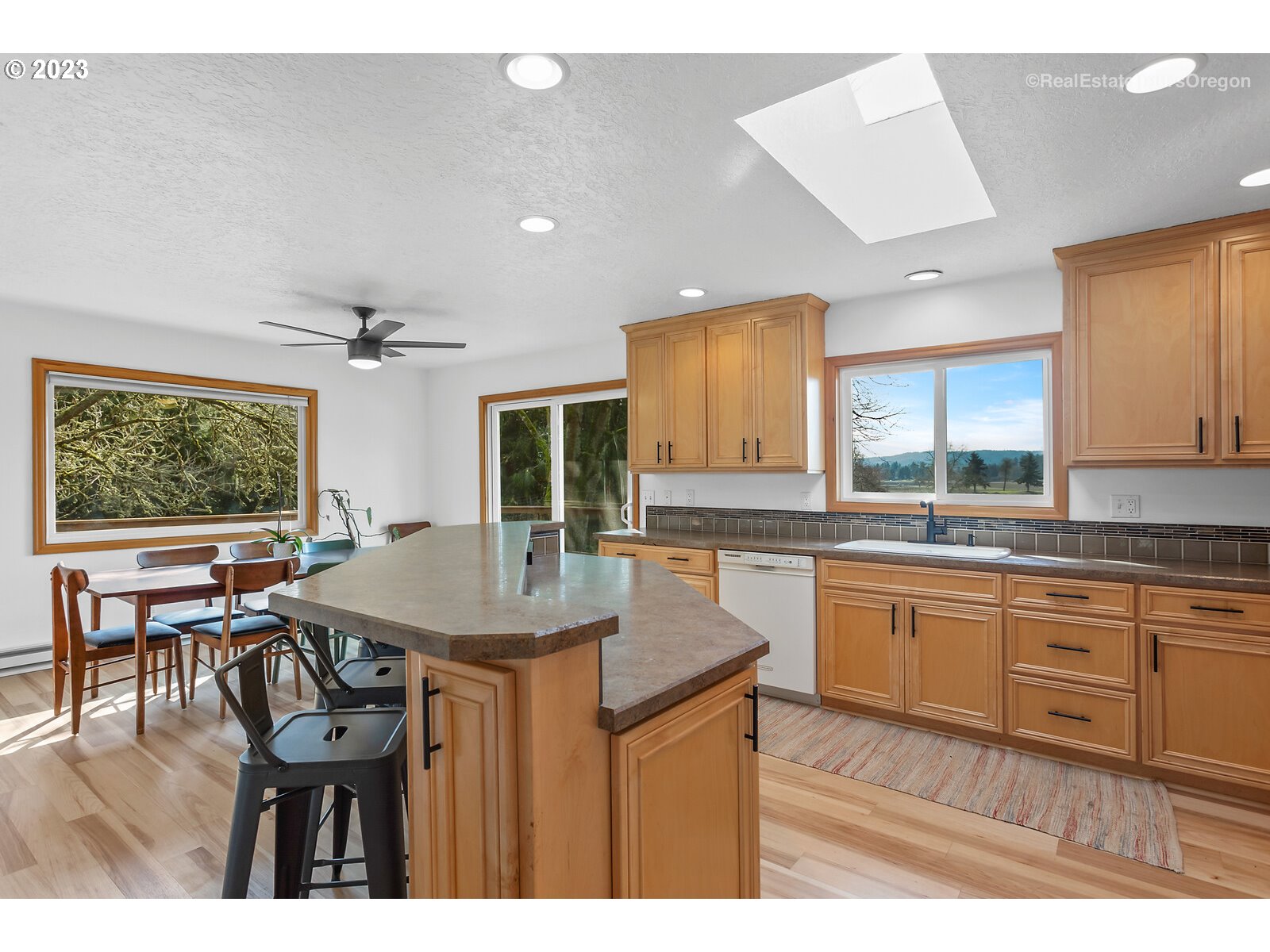17224 Northwest Lucy Reeder Road Portland, OR 97231 - Photo 7 of 27 a kitchen with a table chairs sink and cabinets