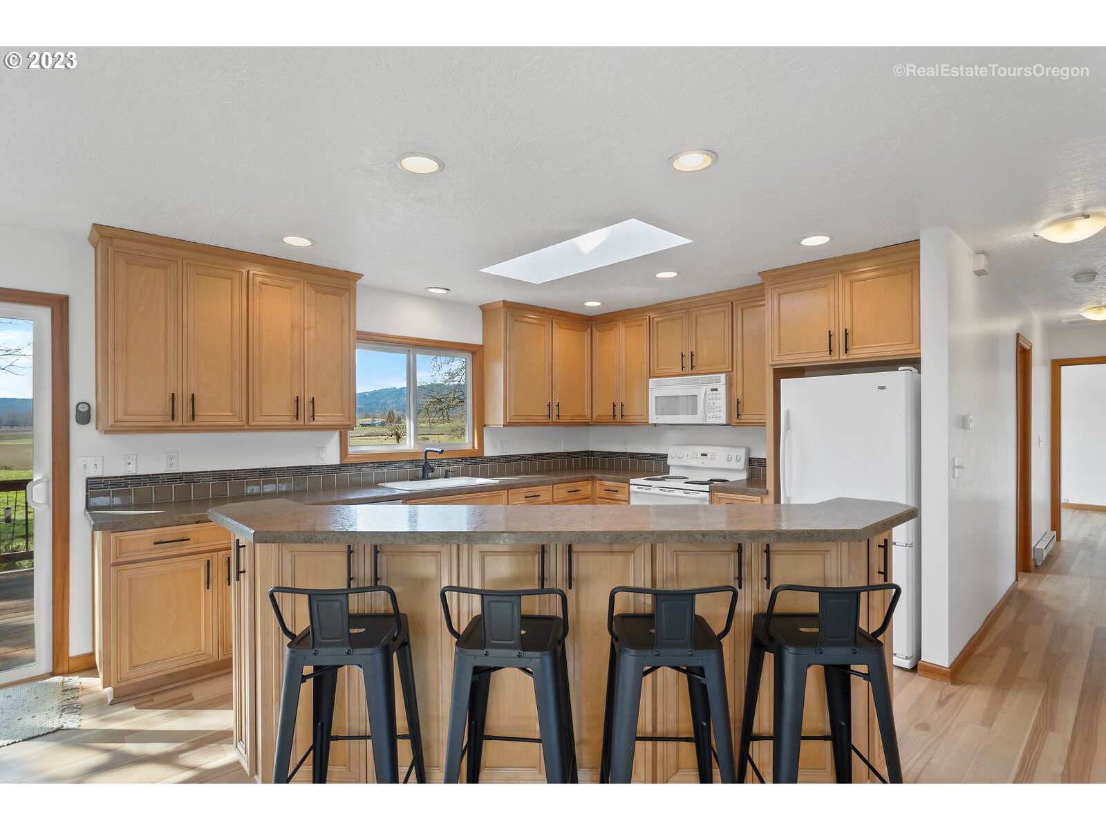17224 Northwest Lucy Reeder Road Portland, OR 97231 - Photo 8 of 27 a kitchen with cabinets and chairs