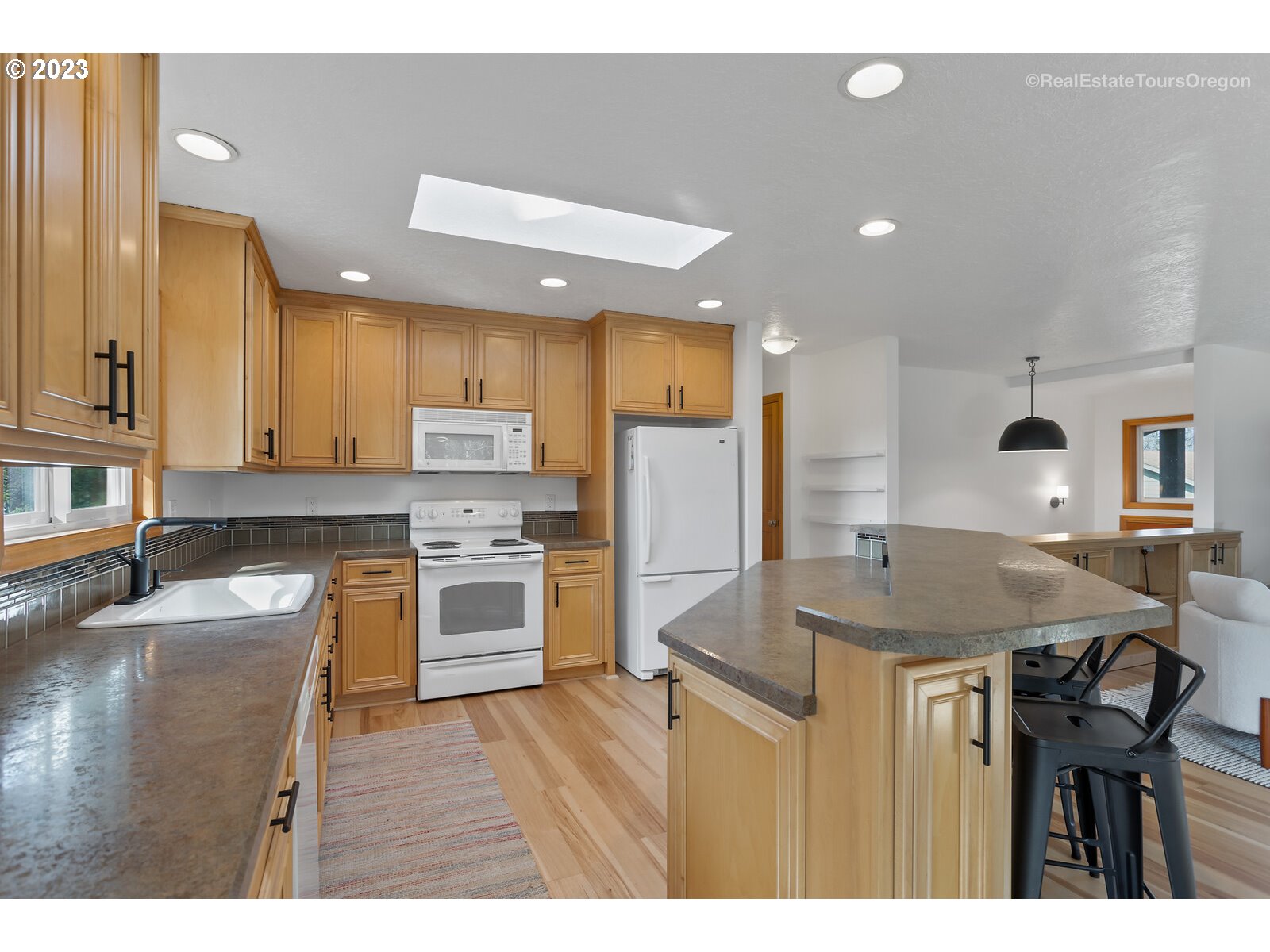 17224 Northwest Lucy Reeder Road Portland, OR 97231 - Photo 9 of 27 a kitchen with refrigerator a stove a sink and a cabinets
