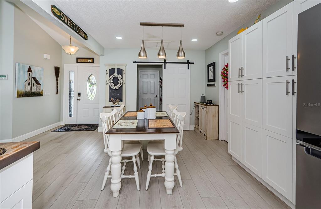 7547 Landmark Drive Spring Hill, FL 34606 - Photo 11 of 34 a kitchen with stainless steel appliances a dining table chairs refrigerator and sink
