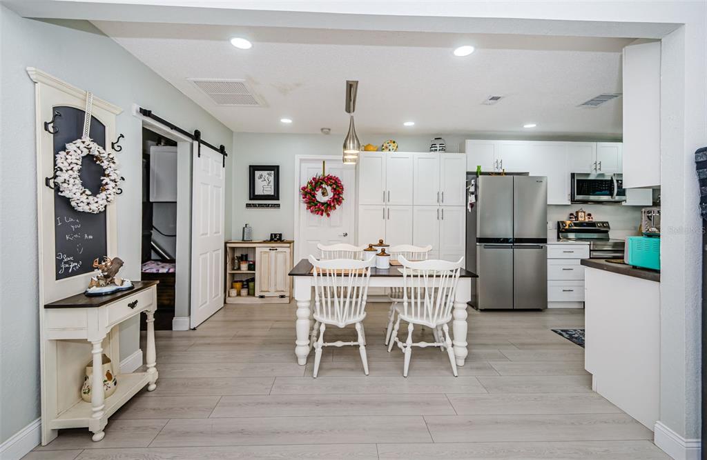 7547 Landmark Drive Spring Hill, FL 34606 - Photo 10 of 34 a kitchen with stainless steel appliances a refrigerator a stove a sink a dining table and chairs