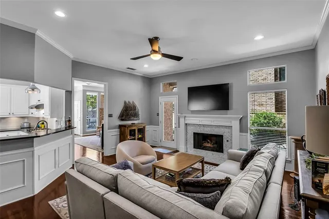 a living room with furniture a fireplace a flat screen tv and potted plant