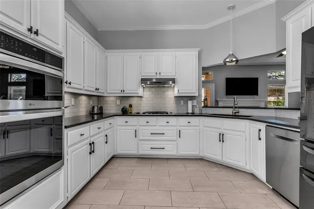 a kitchen with granite countertop white cabinets and white appliances