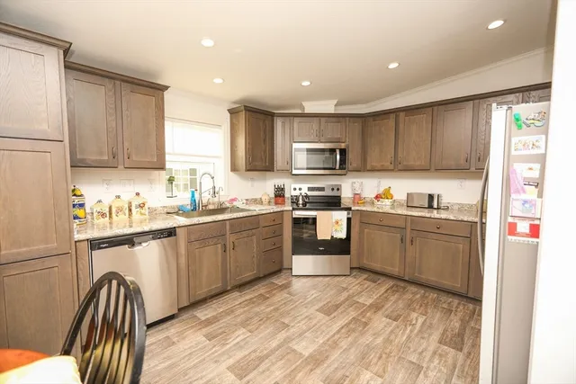a kitchen with kitchen island granite countertop wooden cabinets a sink a stove a oven with a dining table and chairs