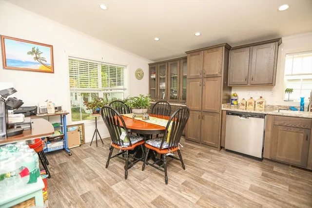 a view of a dining room with furniture a kitchen and chandelier