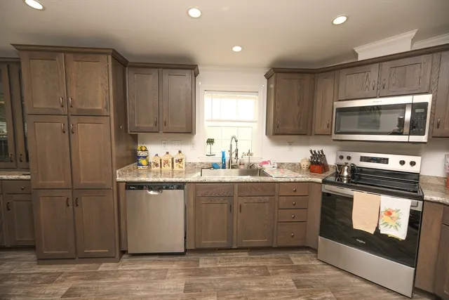 a kitchen with stainless steel appliances granite countertop a stove top oven a sink dishwasher and a microwave oven on the blue kitchen countertops