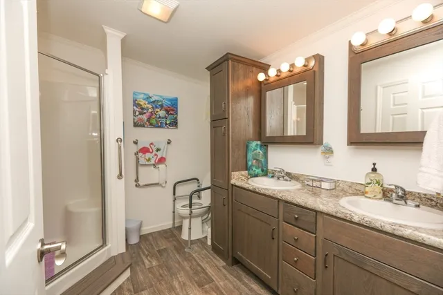 a bathroom with a granite countertop sink a mirror a vanity and shower