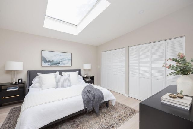 a bedroom with a bed and a potted plant