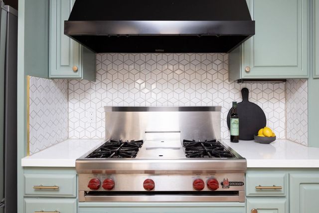 a stove top oven sitting inside of a kitchen