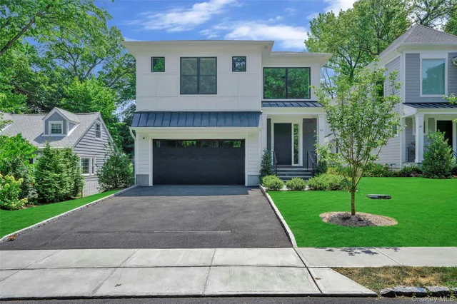 a front view of a house with a yard and a garage