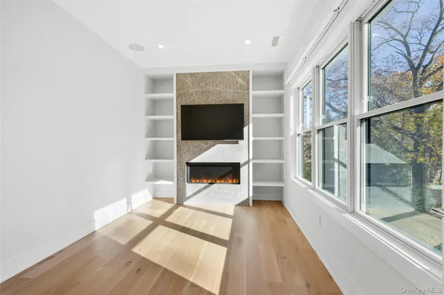 a view of bedroom with a large window and wooden floor