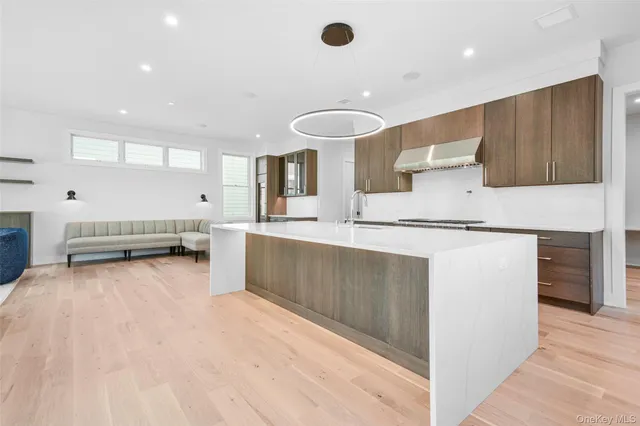 a living room with stainless steel appliances kitchen island granite countertop a sink and cabinets